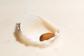 An almond falling into almond milk