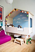 Modern cubby bed with painted wall and fairy lights in child's bedroom with Scandinavian ambiance