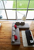 View down into elegant seating area with exotic-wood parquet floor, glass wall and view of garden