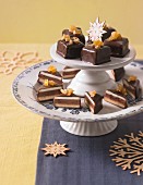 Dominosteine (chocolate covered sweets with marzipan and gingerbread) on a cake stand for Christmas
