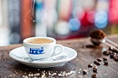 Espressotasse, Zucker, Kaffeebohnen und Kaffeepulver auf Holztisch