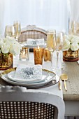 Festlich gedeckter Tisch mit vergoldeten Vasen, Goldrandteller und Goldbesteck