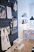 Black board wall used as oversized pinboard; dining area with folding table in background