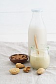 A jar of almond mousse and almond milk in a glass milk
