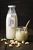 A jar of cashew mousse and cashew nut milk in a glass bottle