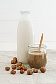 A jar of hazelnut mousse and hazelnut milk in a glass bottle