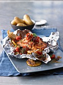 Mediterranean salmon fillet with cherry tomatoes and lemons cooked in foil