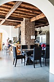 Offenes Wohnen in renoviertem italienischem Landhaus mit rustikaler Holzbalkendecke und Mauerpfeiler