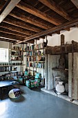 Reading corner in historical interior with rustic wood-beamed ceiling and modern concrete floor
