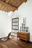 Antique chest of drawers, framed modern sculptures and large chimeric sculpture in renovated attic room