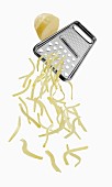 A vegetable grater with grated potato
