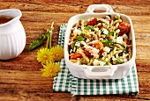 A pasta salad with dandelions, tomatoes and olives