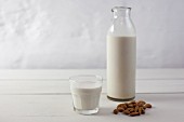 Almonds, and almond milk in a glass and in a bottle