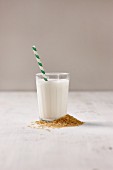 A glass of vegan rice milk with a straw