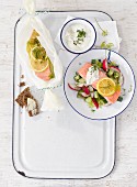 Ofen-Lachs auf Gurken-Radieschen-Salat mit Kräuterdip und Vollkornbrot