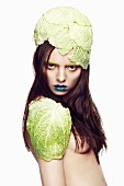 A woman with cabbage leaves on her head and shoulders