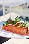 Raw salmon fillets topped with a bouquet of vegetables