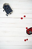 Blueberries and raspberries on a white wooden surface