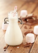 A small bottle of milk with marshmallows and chocolate