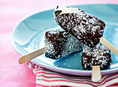 Coconut ice cream sticks with dark chocolate and grated coconut