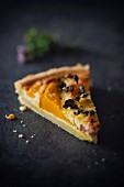 A slice of pumpkin quiche with bacon and Parmesan cheese