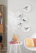 White plates decorated with birds hung on a wall