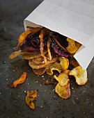 Colourful vegetable crisps with salt and a paper bag