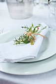 A white napkin with a delicate bouquet of herbs