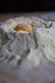 A pile of Italian type 00 flour with an egg cracked into it