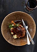 Knuckle of lamb on mashed potatoes with red wine gravy