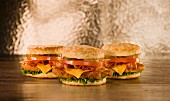 Biscuit-Sandwiches mit Hähnchen, Bacon, Tomaten, Käse und Essiggurken