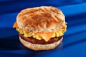 Fried sausage, cheese and scrambled egg on an American biscuit