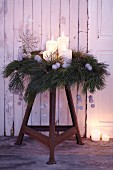 An advent wreath made from pine sprigs and silver, spray-painted plane fruits