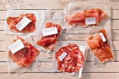 Various types of raw ham with labels
