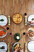 A table laid for Christmas dinner with a roast, sides and pie