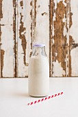 A bottle of cashew nut milk with a straw next to it