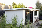 White summer house and terrace in summery garden