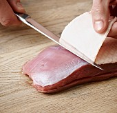 Skin being removed from a duck breast