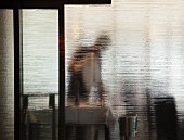 Kellner hinter Glaswand im Restaurant