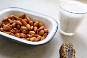 Honey comb, soften, drained almonds and a glass of almond milk