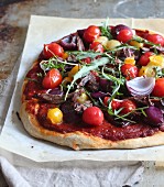 Pizza with beef, cherry tomatoes, onions and rocket