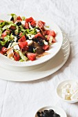 A summer salad with watermelons, olives, feta cheese and prosciutto