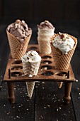 Nut ice cream in ice cream cones in an old egg rack on a dark wooden table