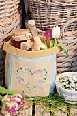 Git bag embroidered with heart motif in front of baskets