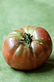 A tomato on a green surface