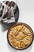 An apple tart in a baking dish (seen from above)