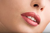 Geschminkter Frauenmund mit roséfarbenem Lippenstift