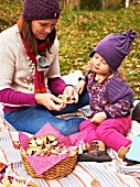 Herbstpicknick: Mutter und Tochter essen Brombeermuffins