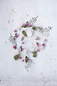 A garland of flowers featuring strawflowers, globa amaranth, corral ferns and wild carrot