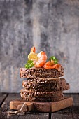 A stack of wholemeal bread slices topped with prawns and smoked salmon